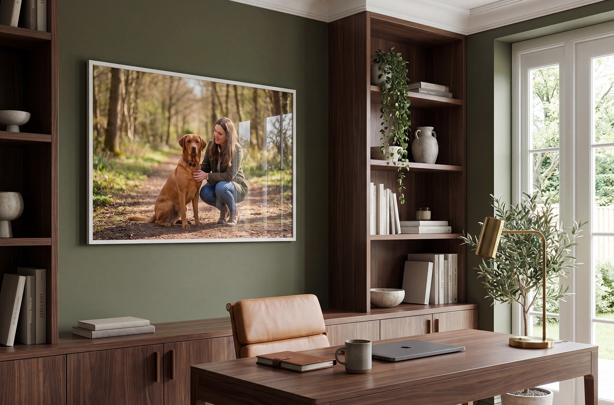 Framed photo print of a dog and their owner hanging in home office
