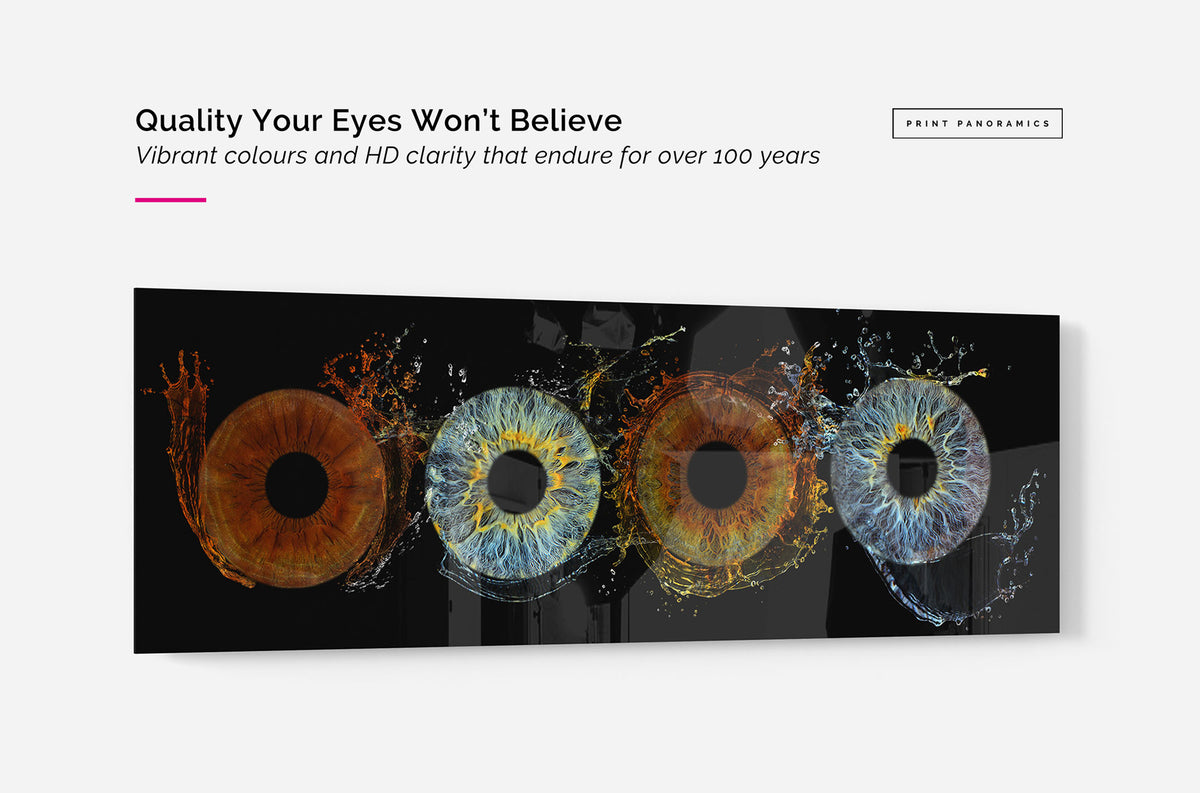 An acrylic panoramic wall art print featuring four stylised human eyes with vivid blue, orange, and yellow iris details on a black background, shown as a mockup on a light grey wall with promotional text above. 