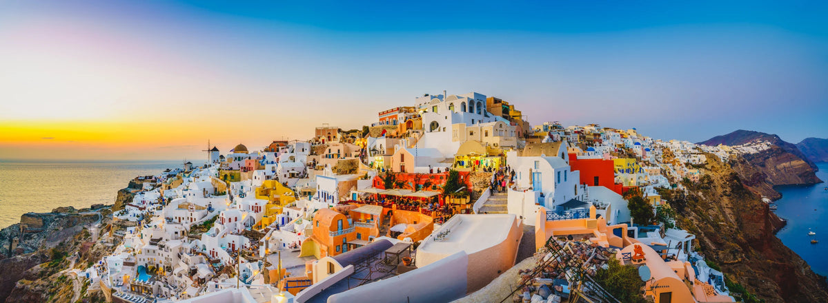 White hillside buildings above the sea at sunset in Santorini