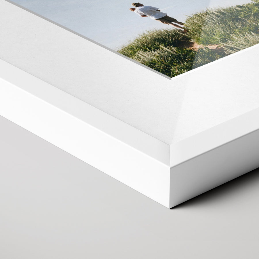 Close-up of a white photo frame and white mount around a photographic print